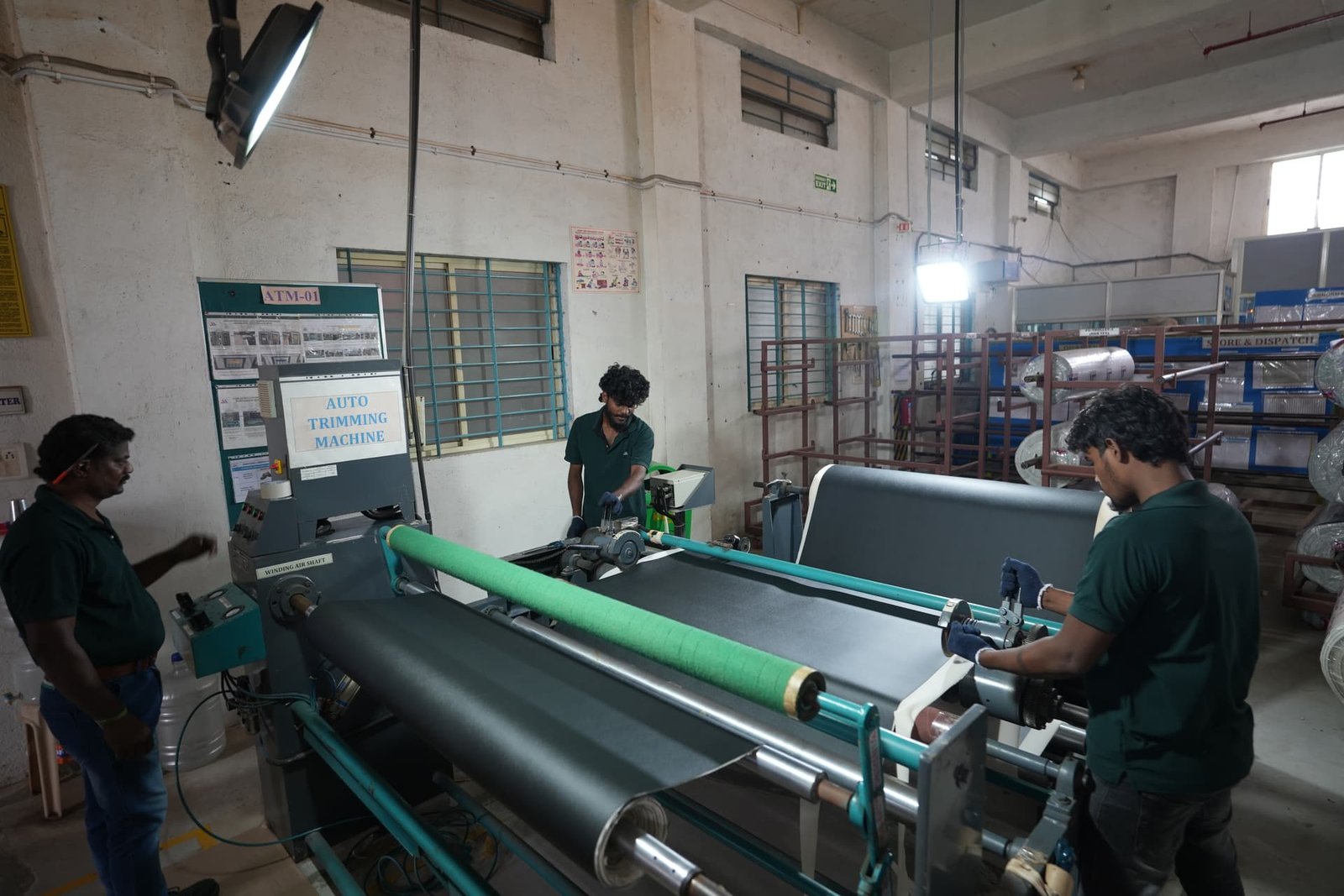Technicians operating the auto trimming machine on the production floor