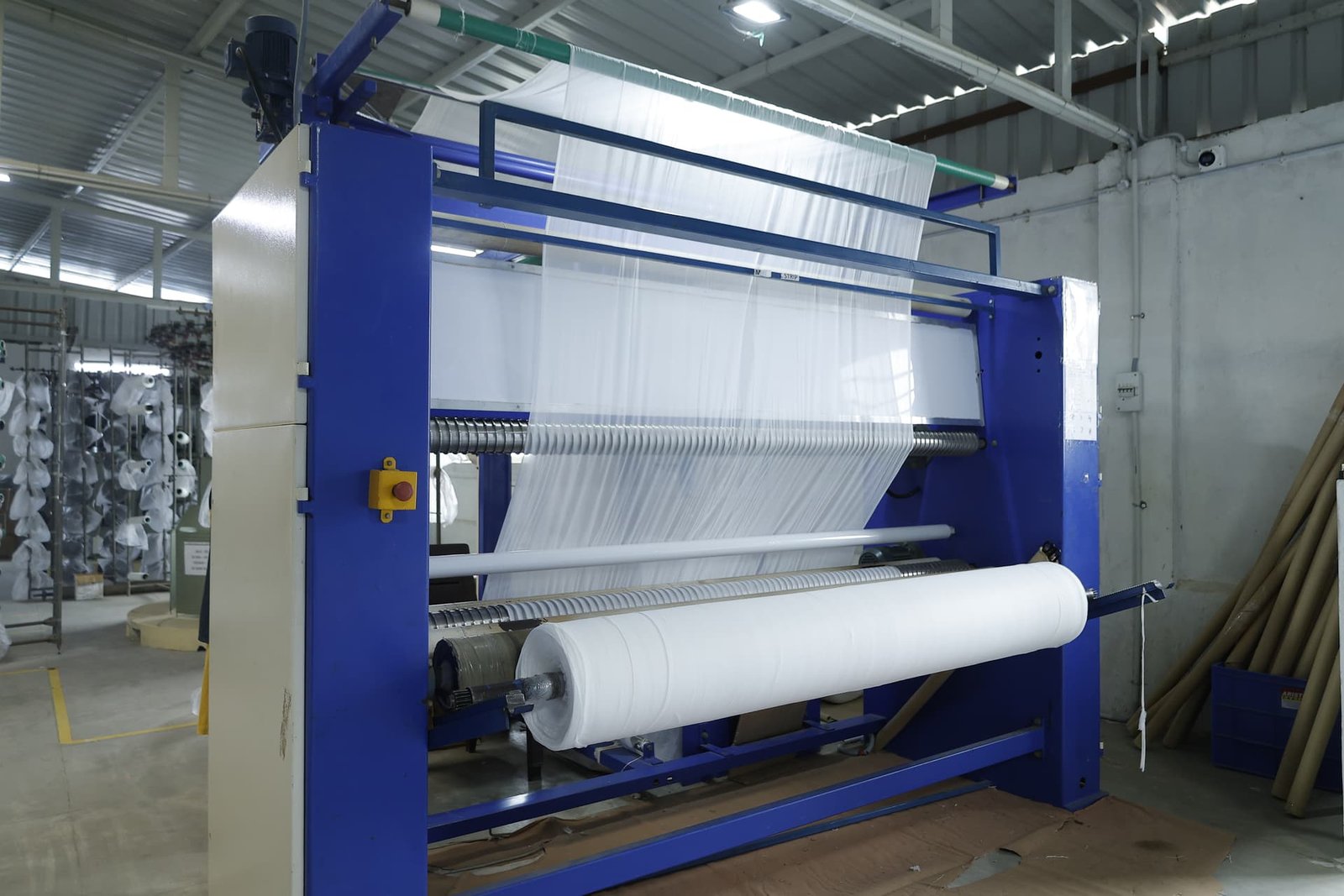 Circular knitting machine winding a fresh roll of knitted fabric