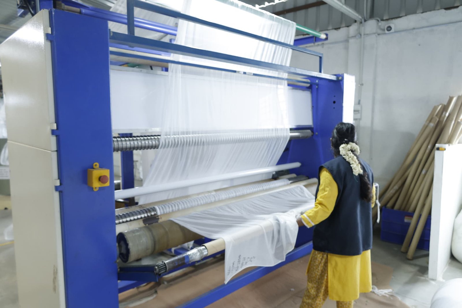 Technician guiding fabric through the circular knitting machine